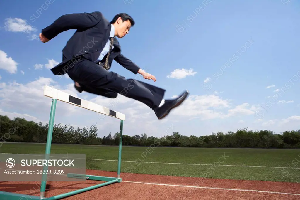 Businessman In His Suit Jumping A Hurdle