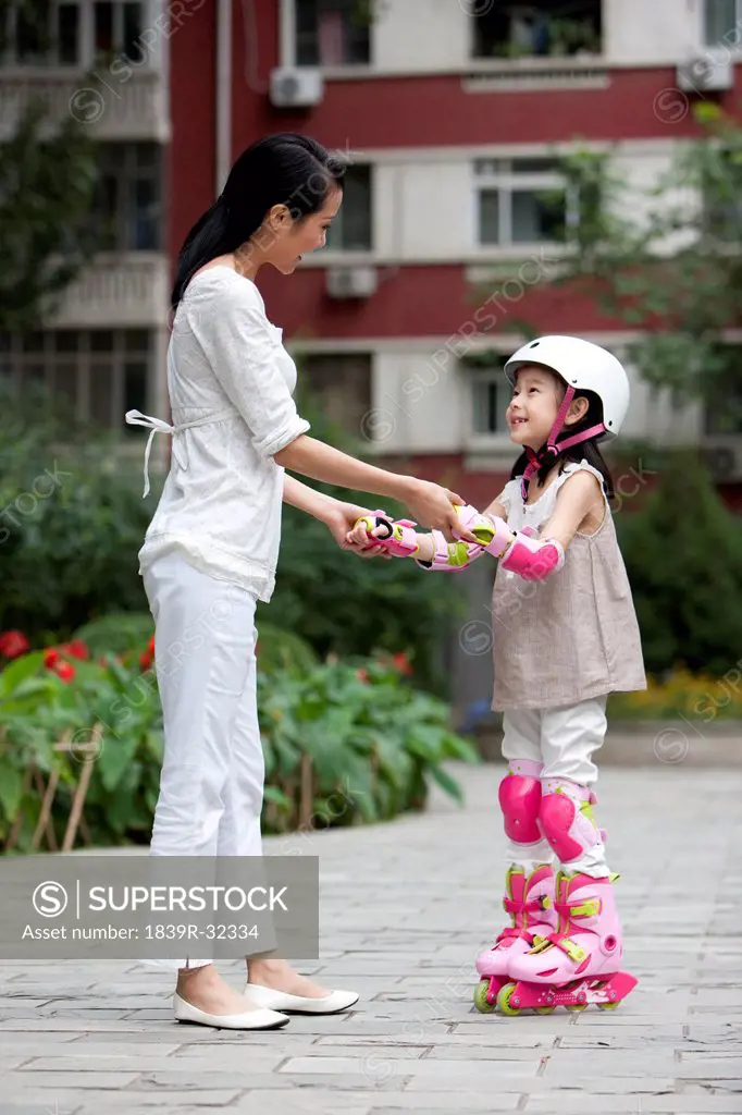 Chinese mother and daughter in rollerblades