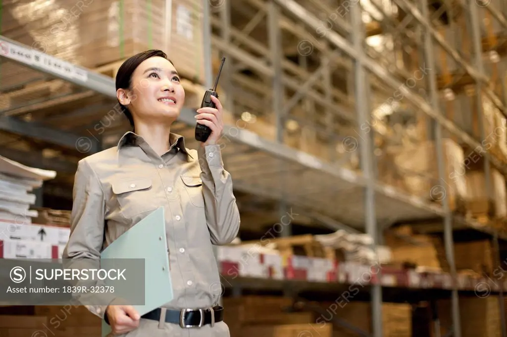 Male Chinese warehouse worker with clipboard