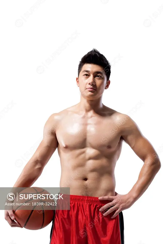 Shirtless muscular man holding a basketball