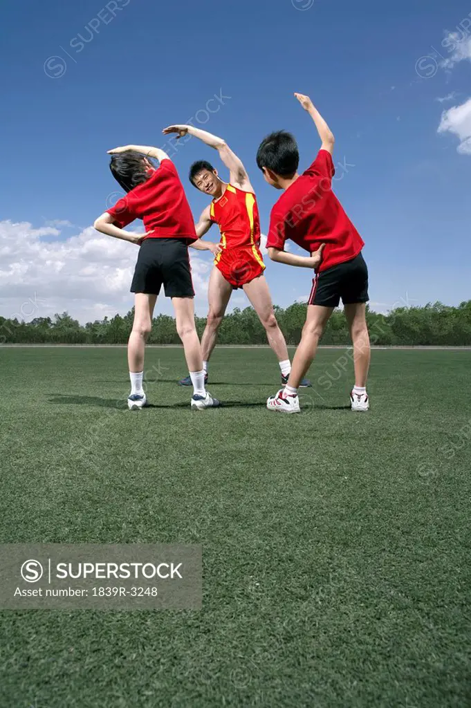 Athletes Stretching In A Field