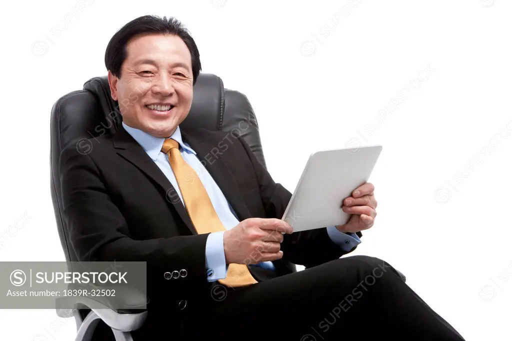 Senior businessman using digital tablet on director´s chair
