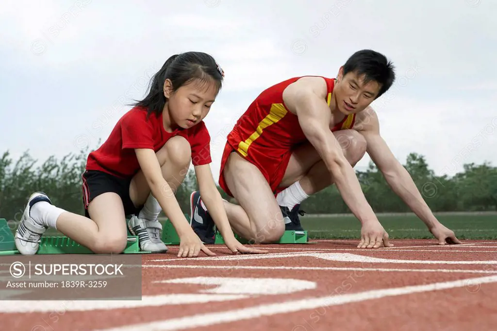 Young Man And Girl Getting Ready To Start A Race