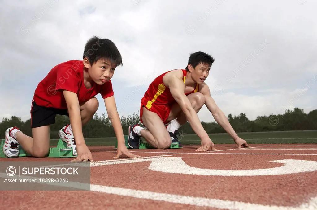 Young Man And Child Getting Ready To Start A Running Race