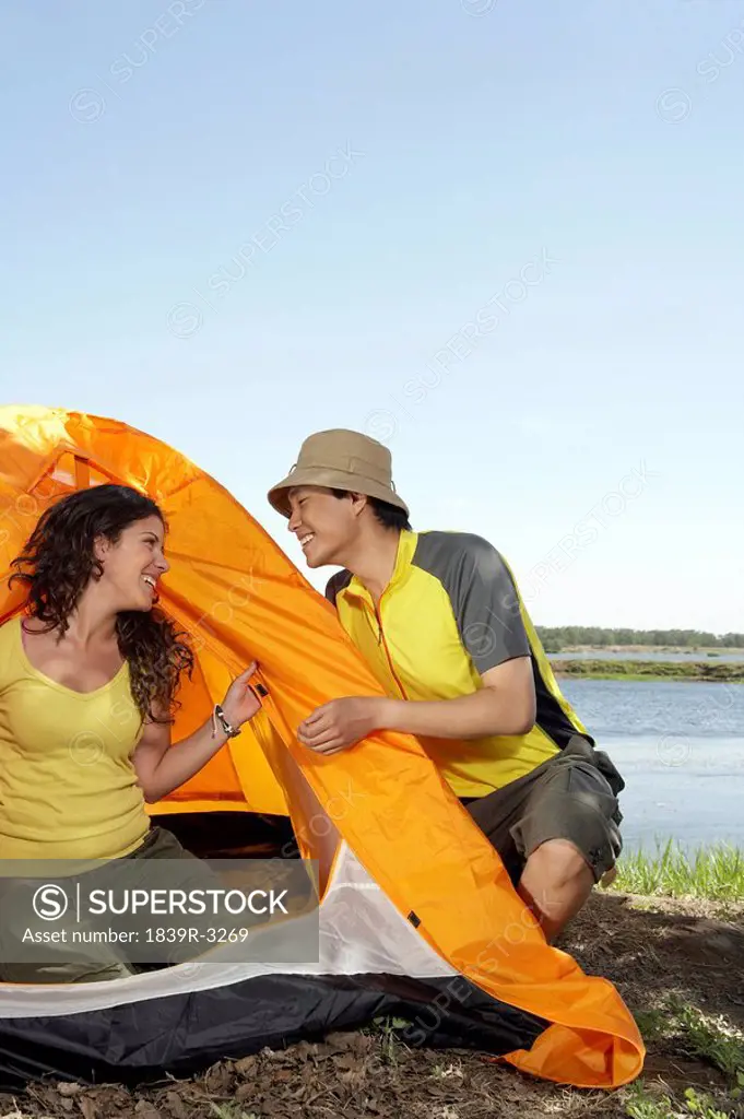 Young Couple Setting Up A Tent While Camping
