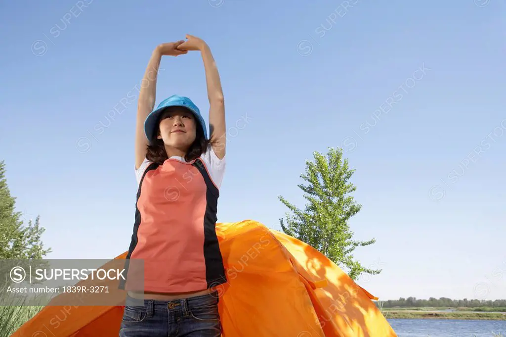 Young Woman Stretching Outside Of A Tent