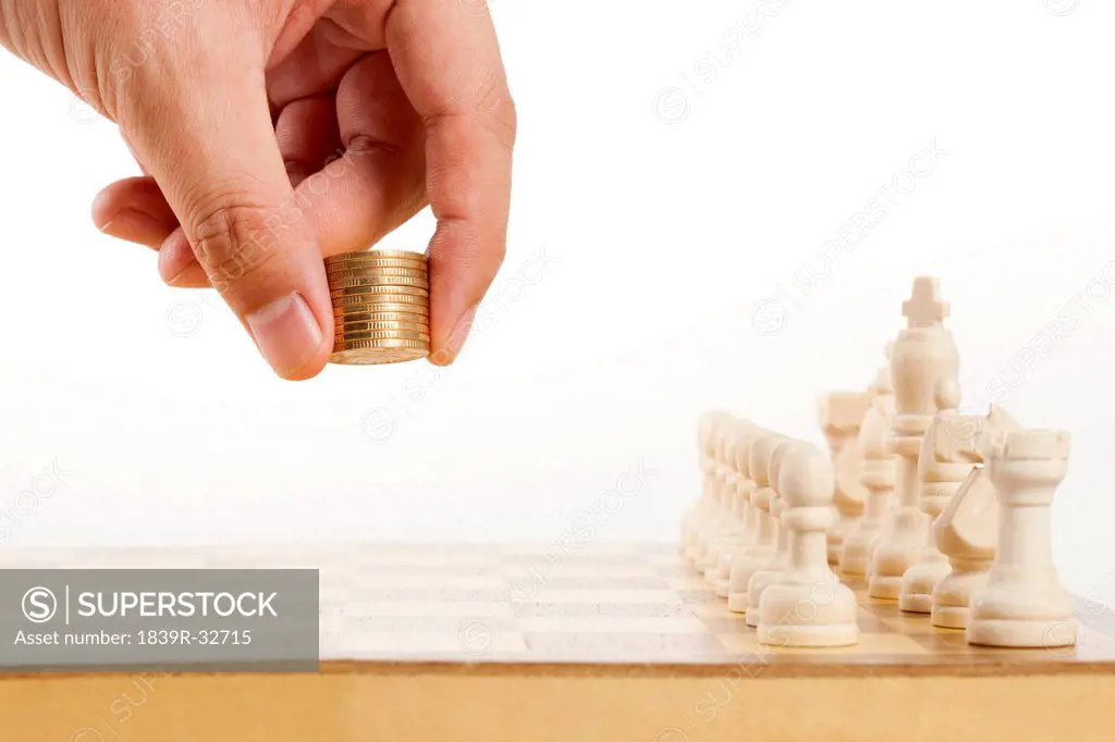Holding coins as chess piece while playing chess
