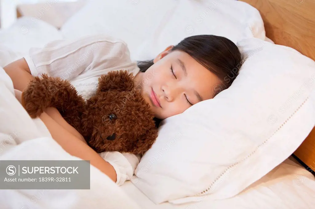 Little girl sleeping soundly with teddy bear