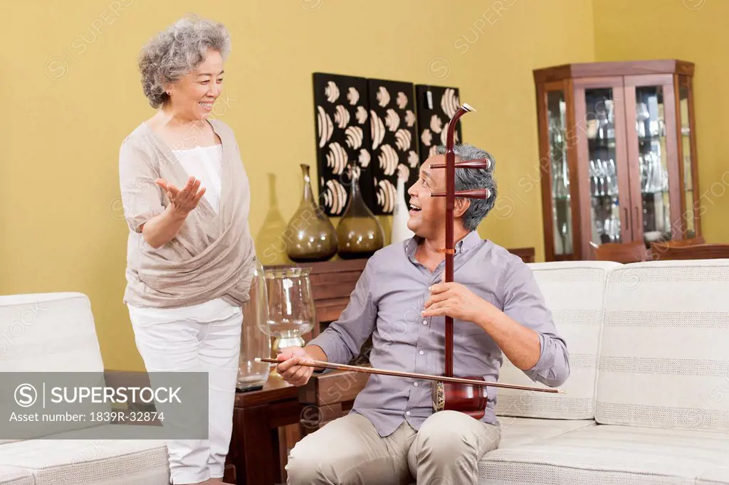 Senior couple playing Chinese traditional musical instrument Erhu