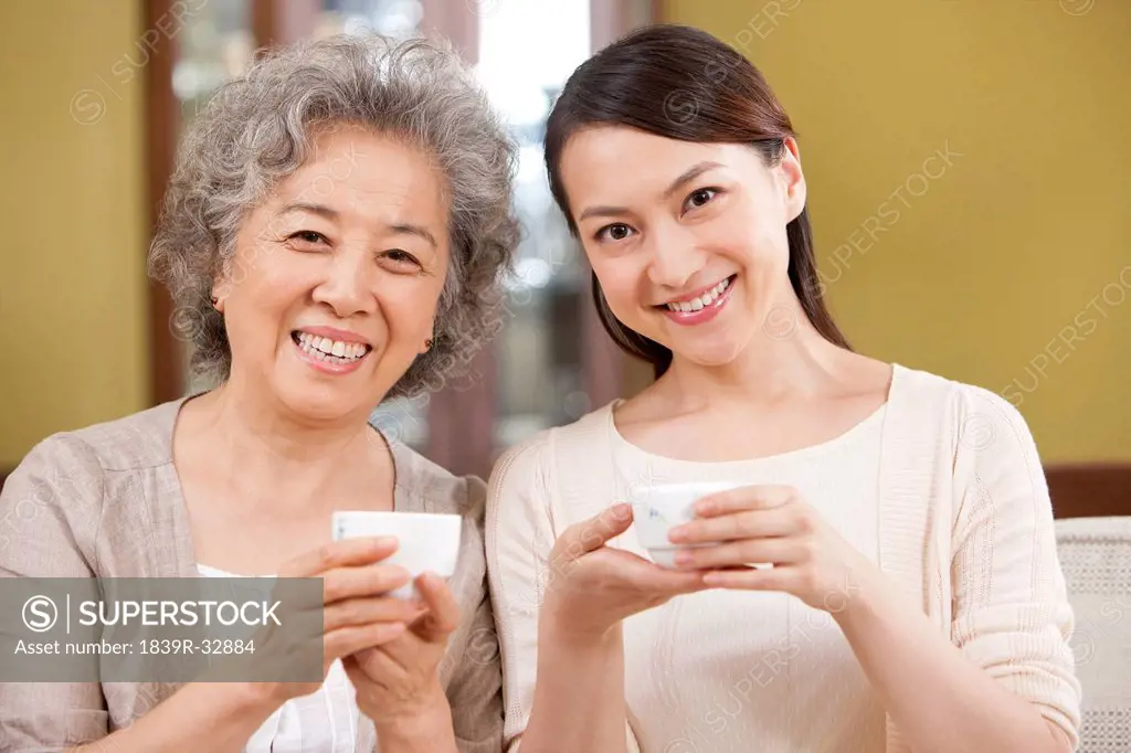 Portrait of young woman having tea with mother