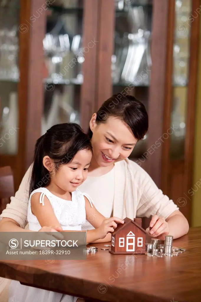 Mother and daughter with coin bank