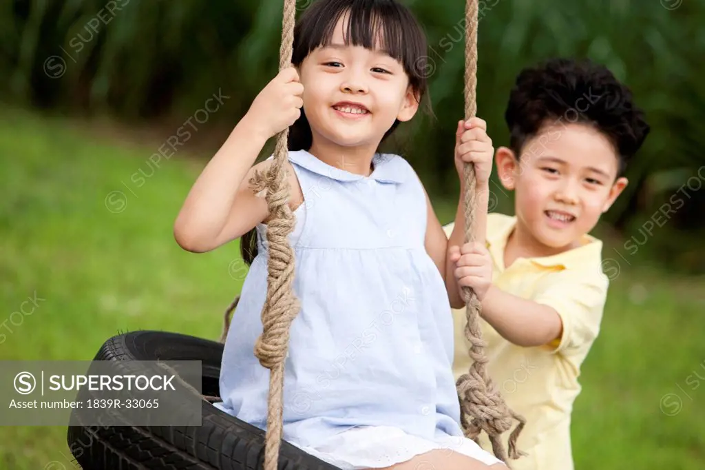 Happy children playing on a swing