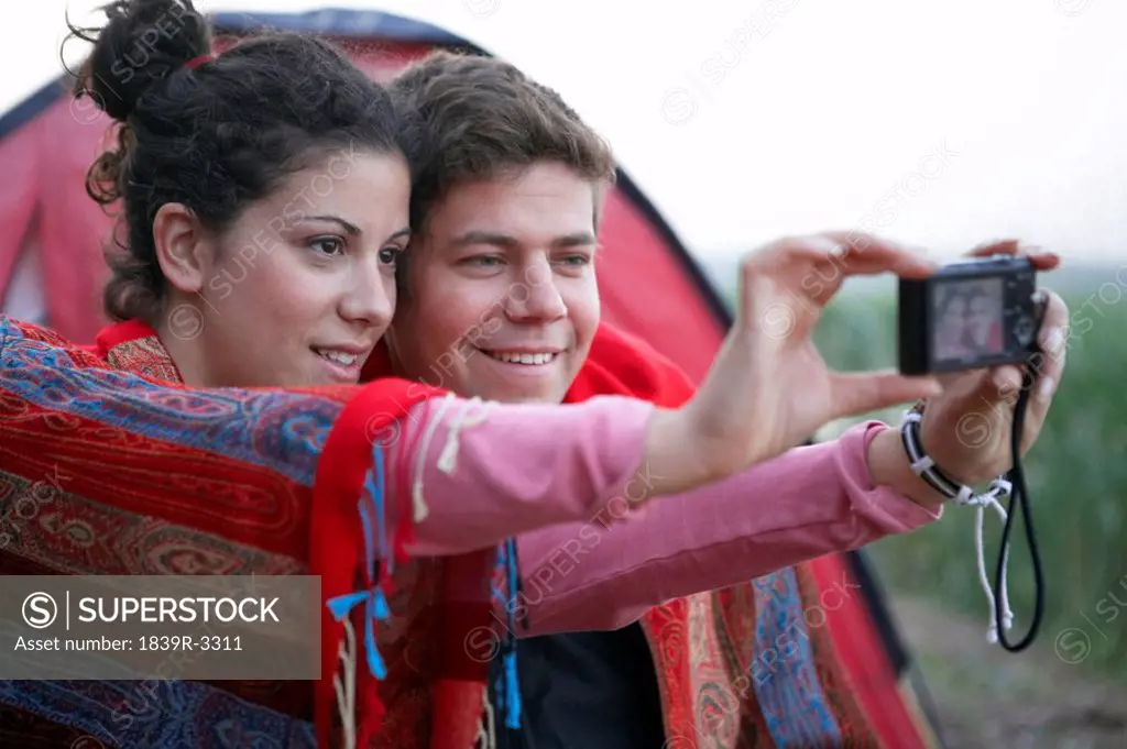 Young Couple Taking Photographs With Camera