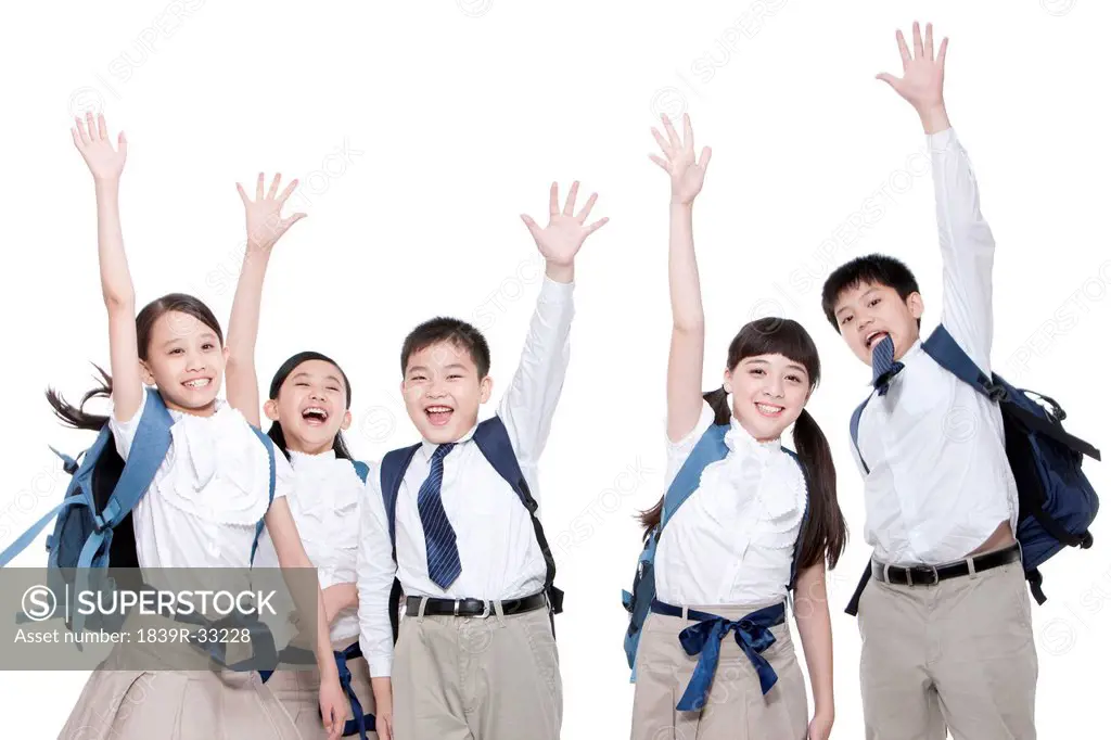 Active schoolchildren raising their hands