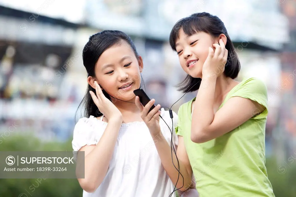 Schoolgirls listening to MP3 player together