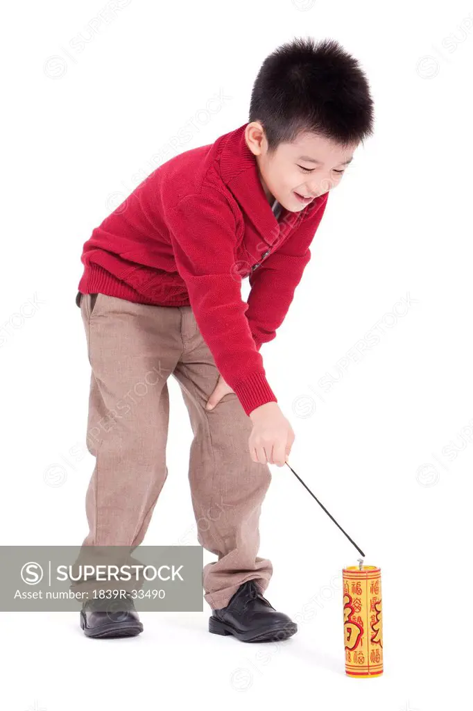Little boy igniting firecracker