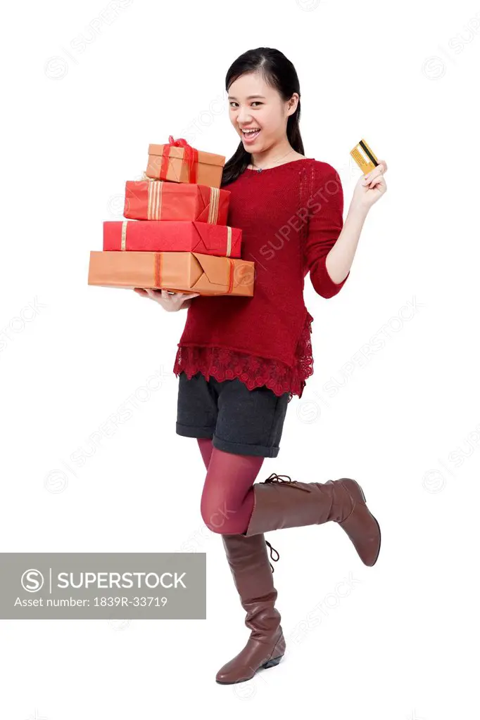 Cheerful young woman with gifts and credit card in Chinese New Year