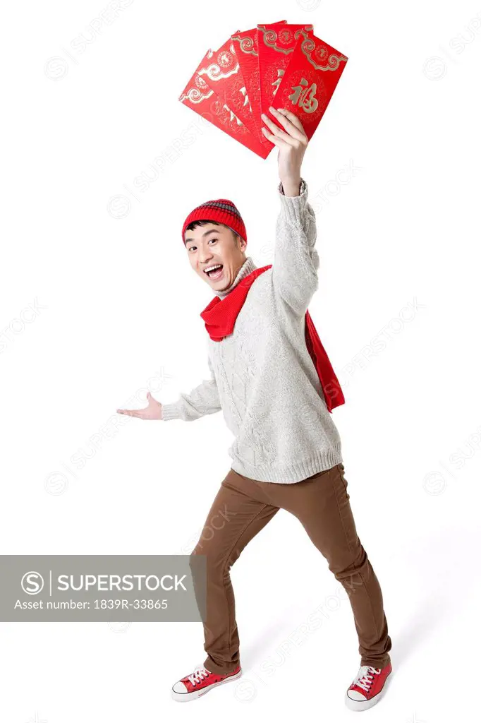 Cute young man celebrating Chinese New Year with red envelops