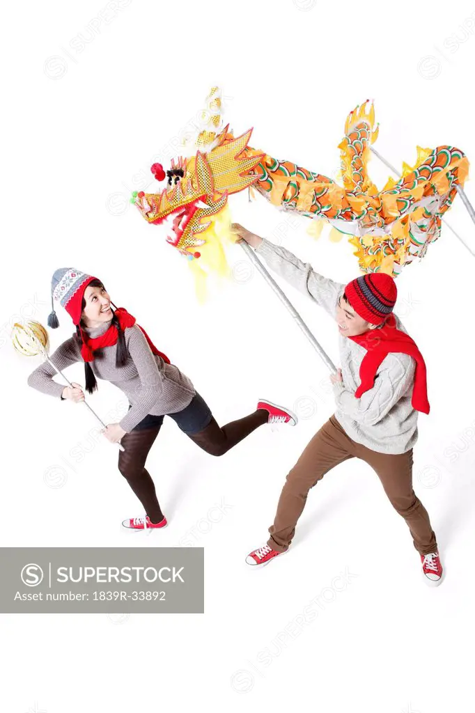 Happy young couple performing dragon dance in Chinese New Year