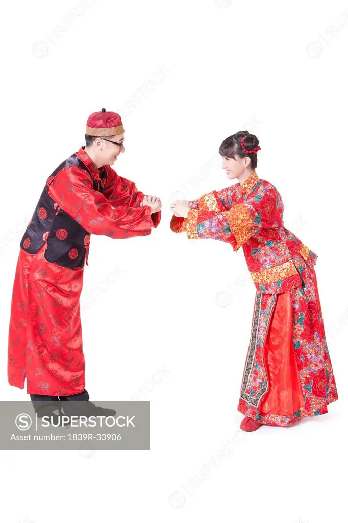 Young couple greeting for Chinese New Year in traditional Chinese clothing