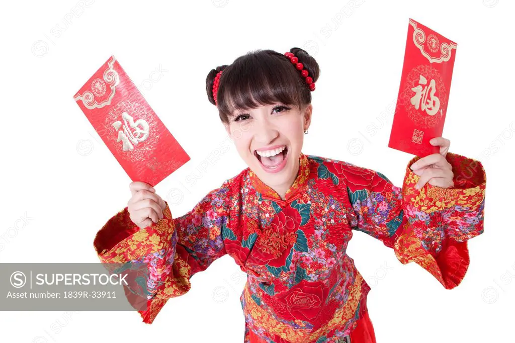 Joyful young woman in traditional Chinese clothing showing red pockets