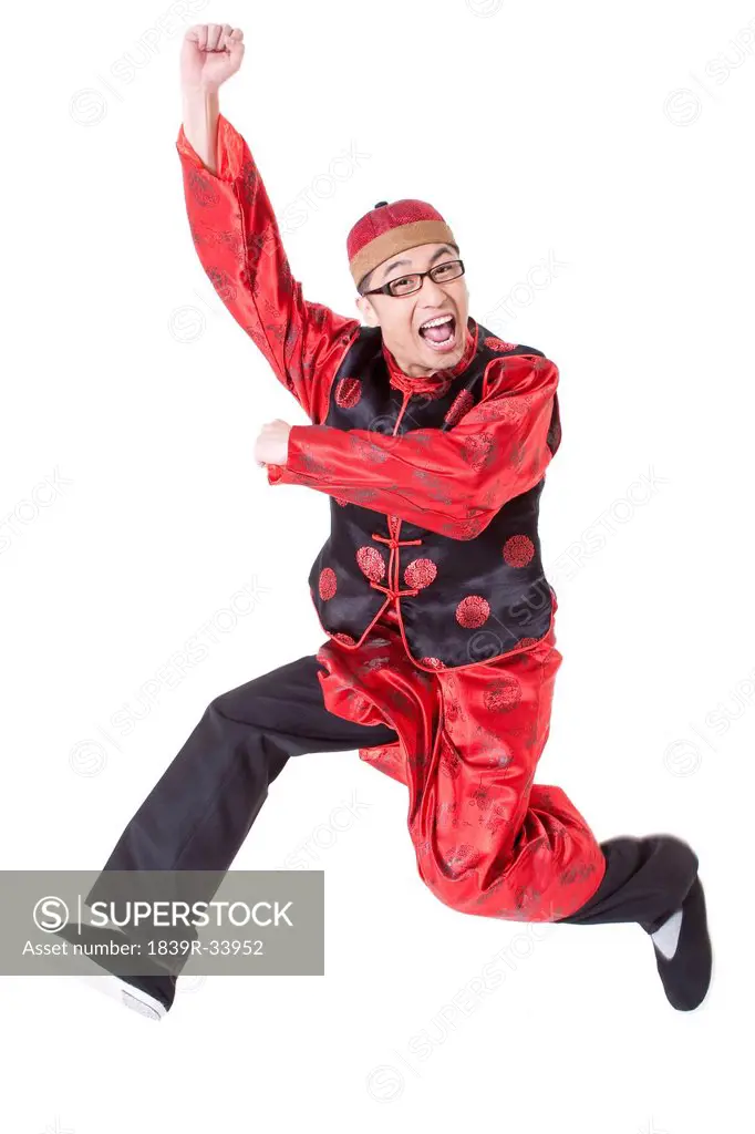 Humorous young man in Tang suit jumping in mid air