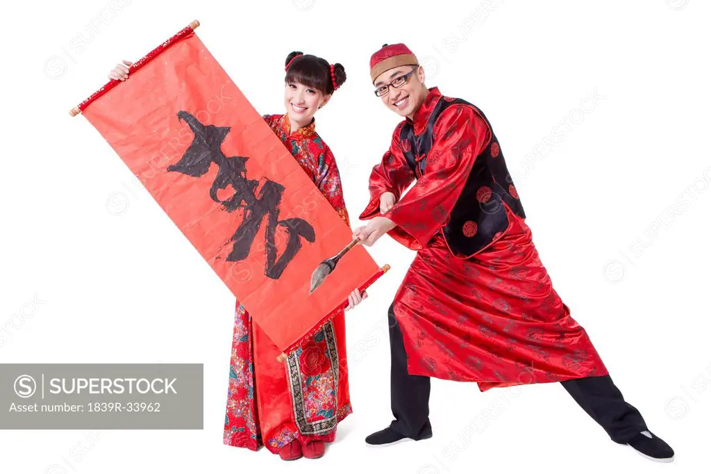 Happy couple in Tang suit practicing calligraphy