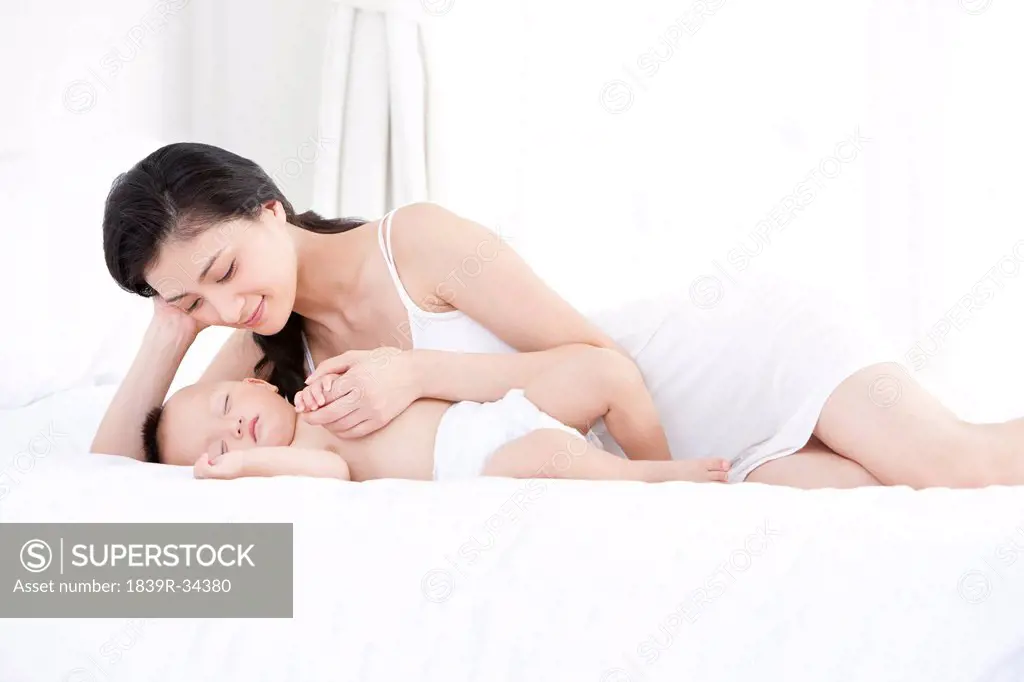 Gentle mother with sleeping baby