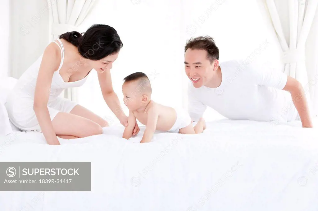 Happy family playing in bed
