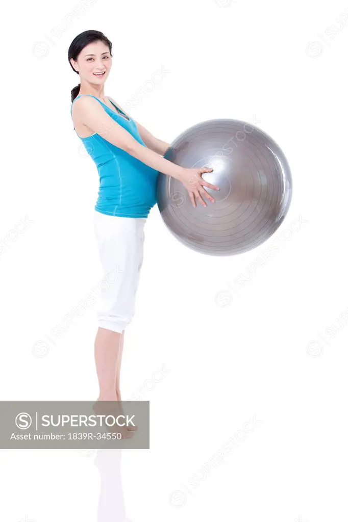 Young pregnant woman and fitness ball