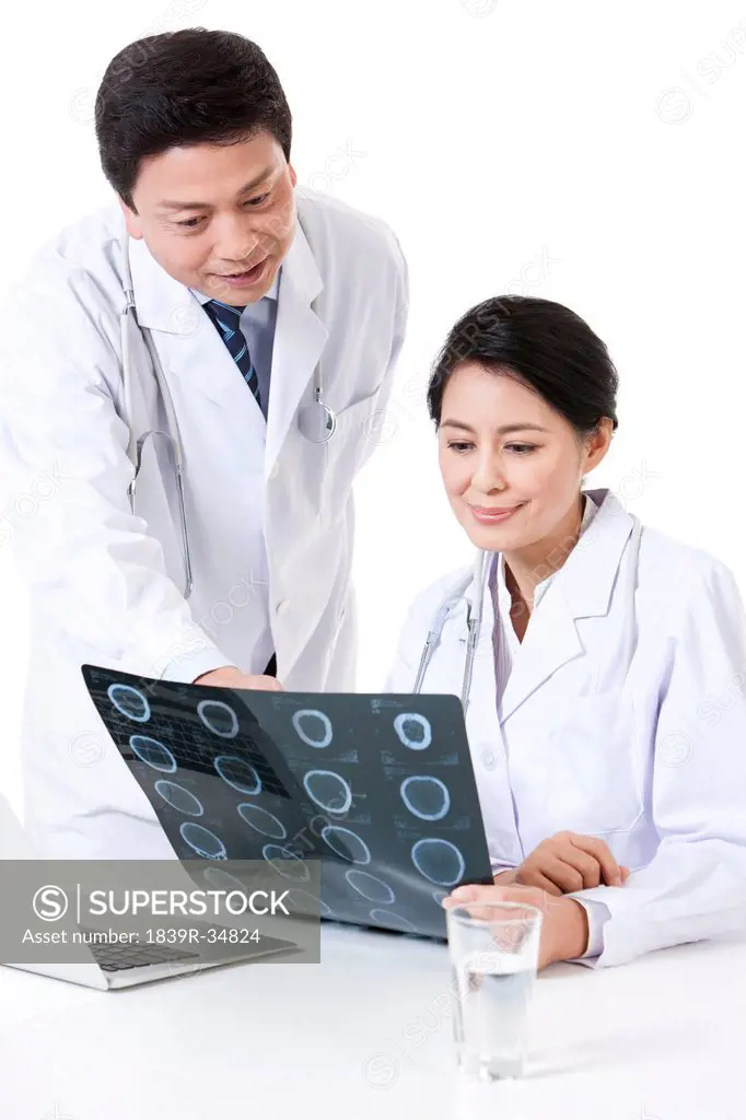 Professional doctor checking X-ray image with colleague