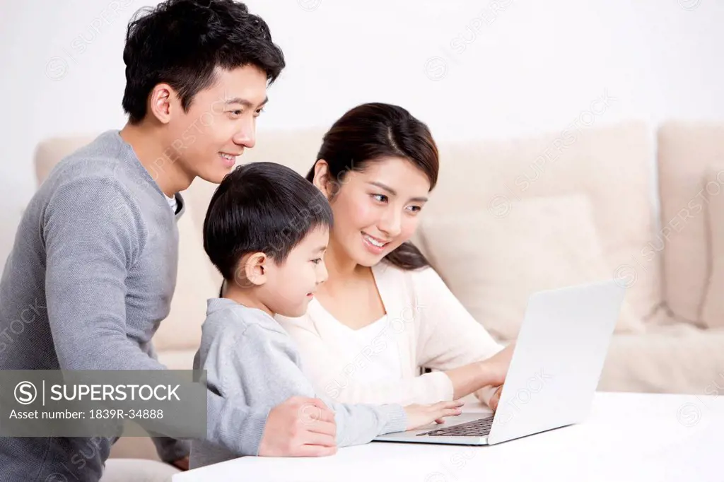 Young family surfing the net with laptop