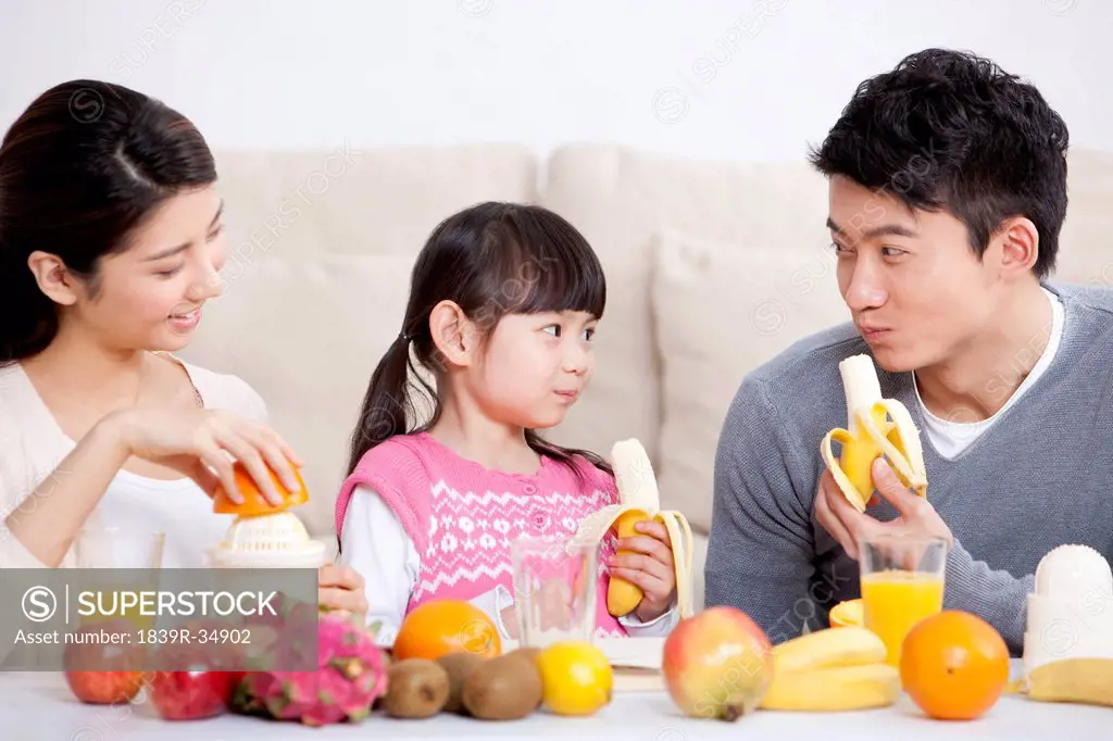 Happy family eating fruits at home