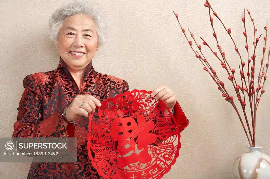 Women Holding Paper Cutting Which Symbolizes Luck