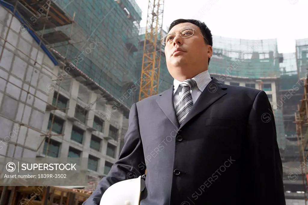 Businessman In A Construction Site Holding A Hard Hat
