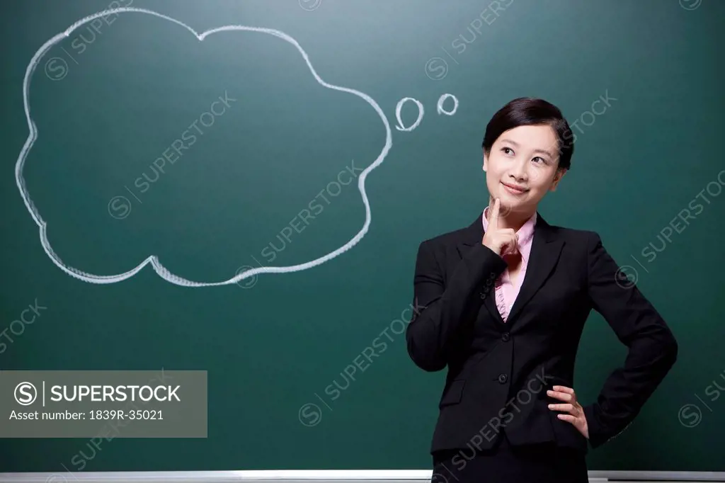 Professional female teacher hand on chin in classroom