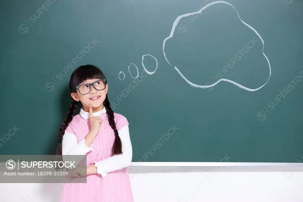 Cute schoolgirl examining insect specimens carefully with magnifying glass
