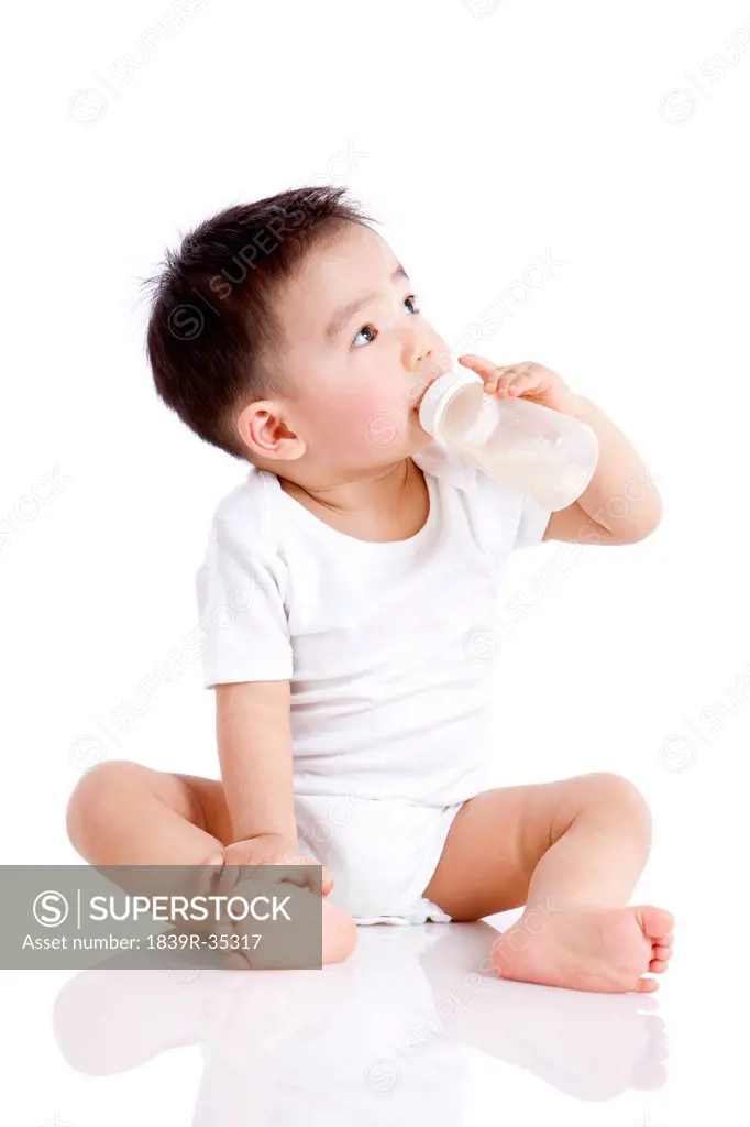 Cute baby boy with baby bottle