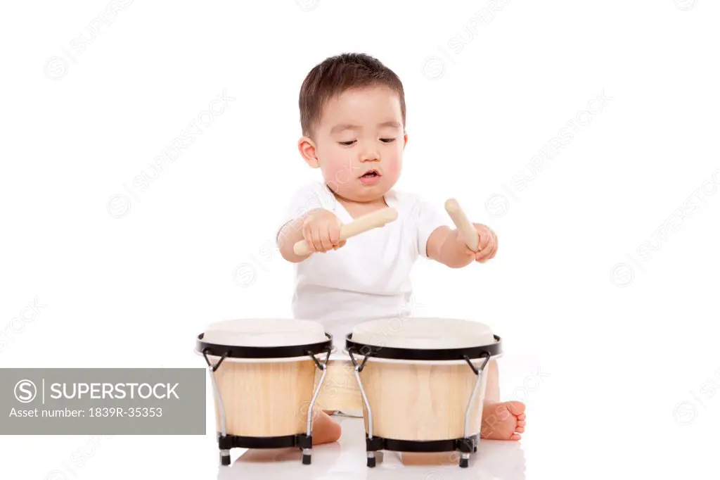 Lovely baby boy playing bongo drum
