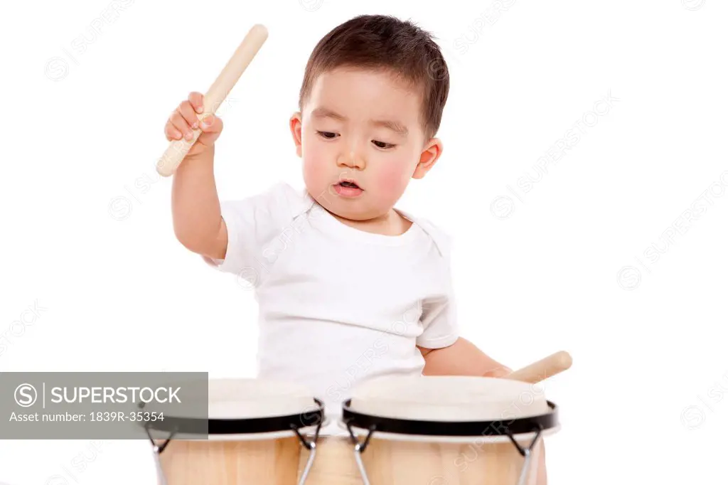 Lovely baby boy playing bongo drum