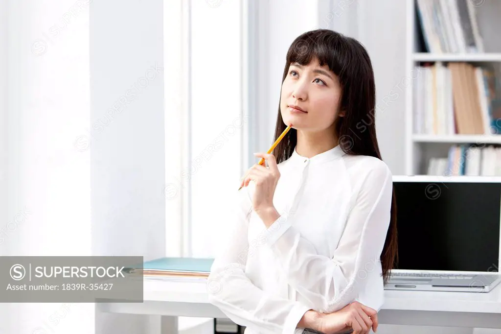 Young businesswoman thinking in the office