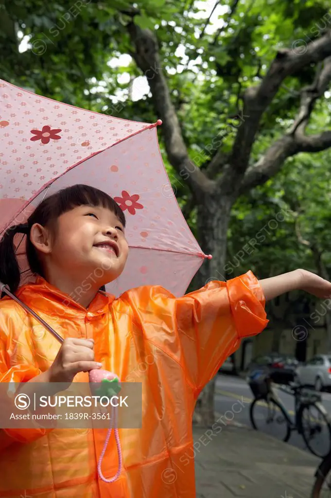 Young Child In The Rain With An Umbrella