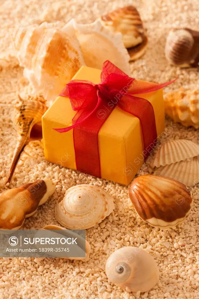 Shell and gift box in sand