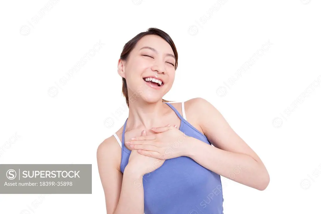 Joyful young woman putting hands on chest