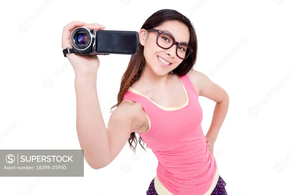 Young woman photographing with home video camera