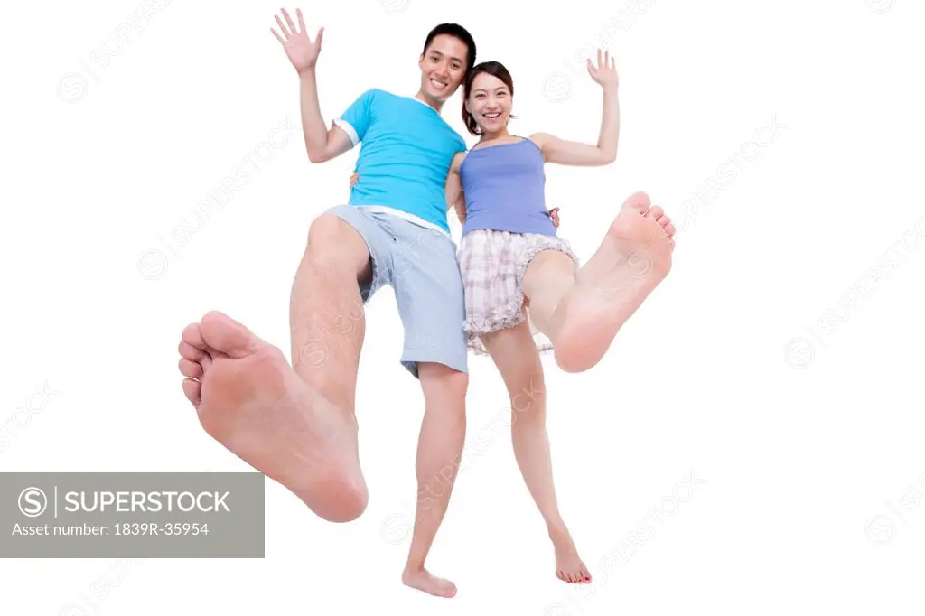 Cheerful young couple walking with bare feet