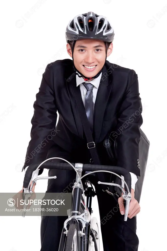 Portrait of young businessman riding a bike