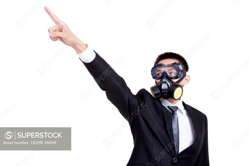Young businessman with gas mask pointing afar