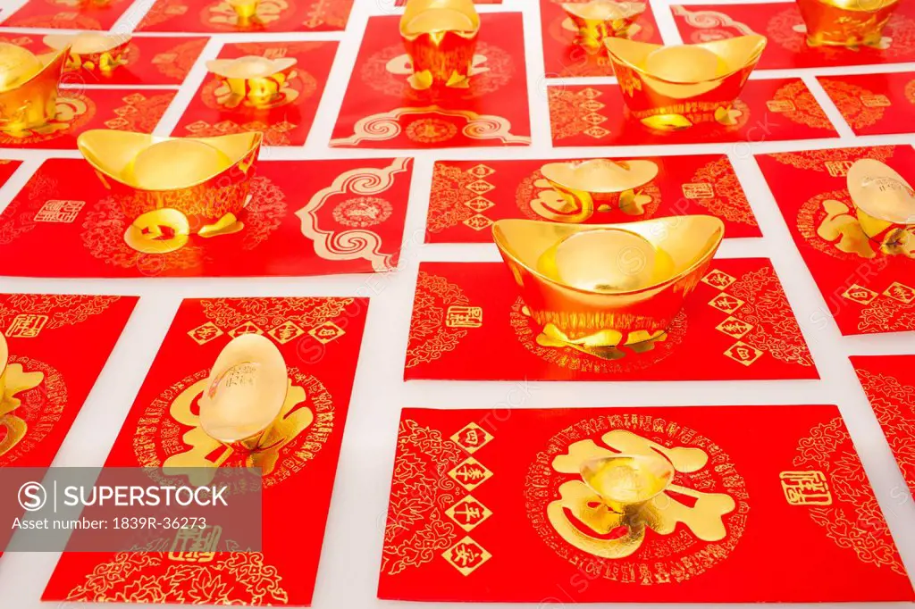 Chinese traditional currency gold yuanbao ingots and red pockets for Chinese New Year