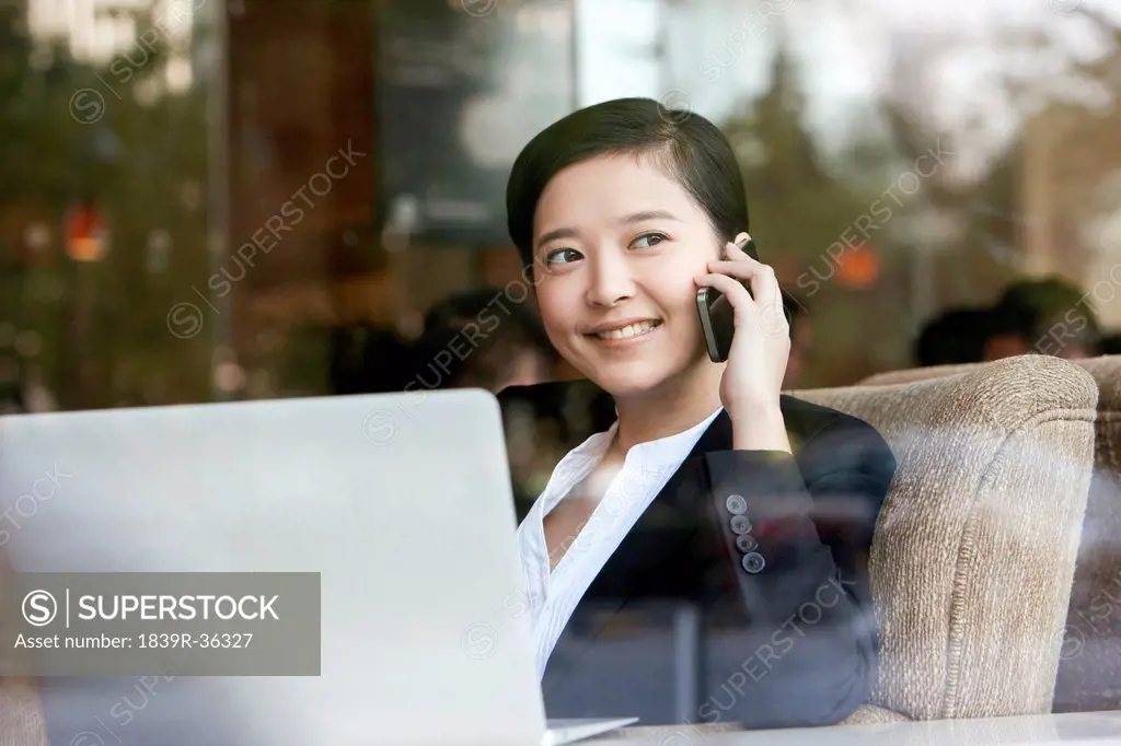 Joyful businesswoman on the phone in cafe